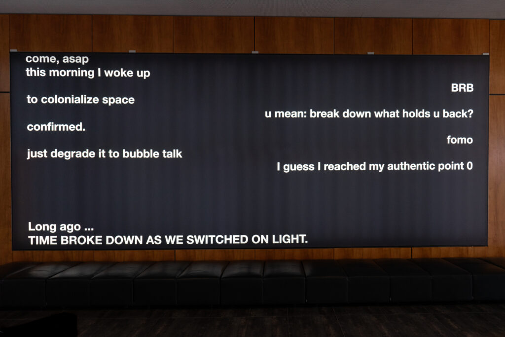 photo of a light-wall showing the work "time broke down ... as we switched on light"